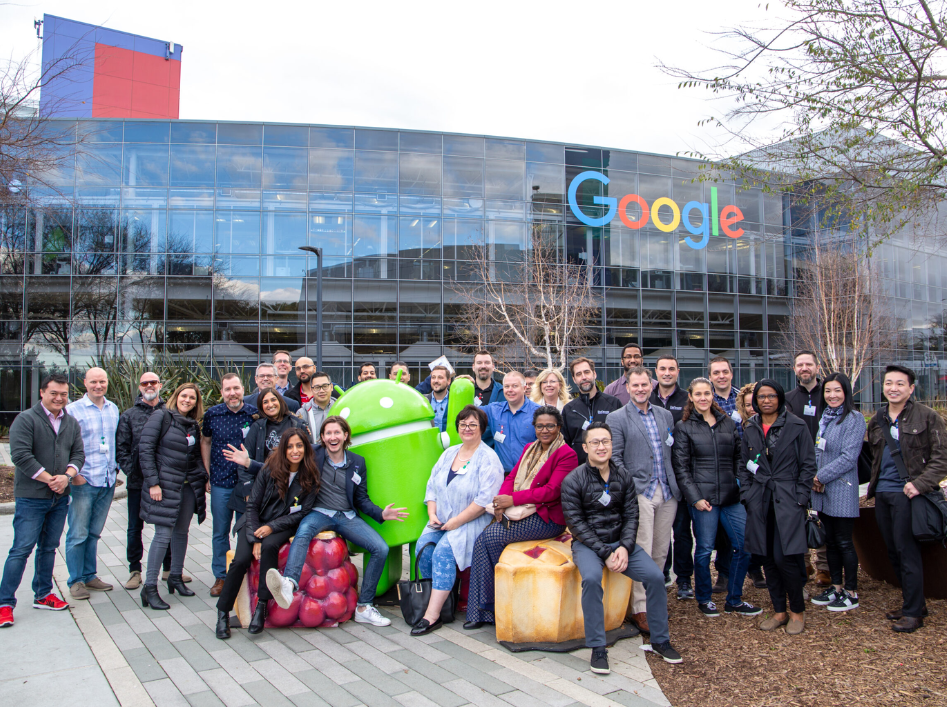 EMBA students pose together with the Android mascot, outside Google's headquarters.